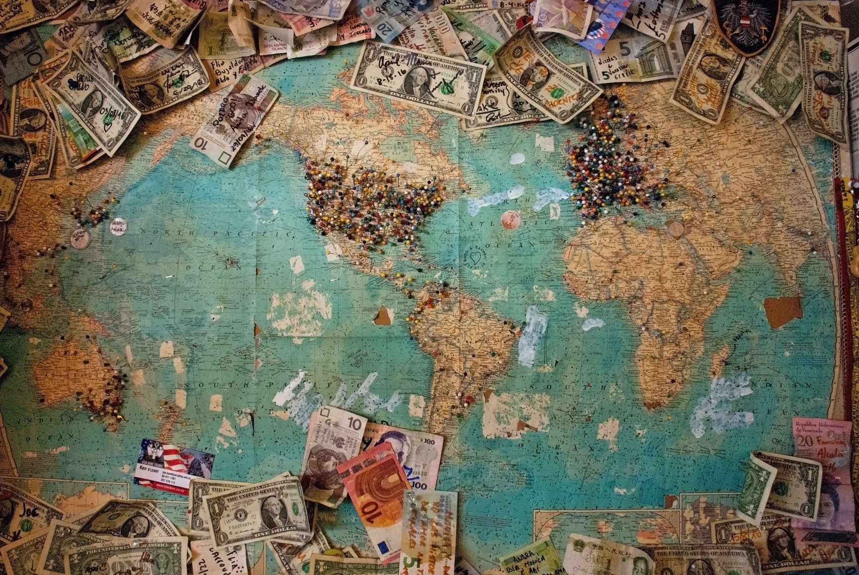 World map with bank notes scattered on it