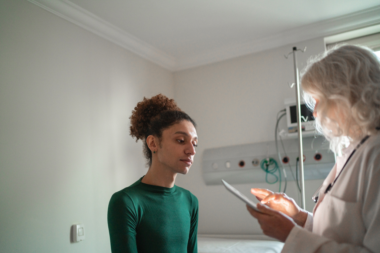 Doctor in hospital setting consults with patient