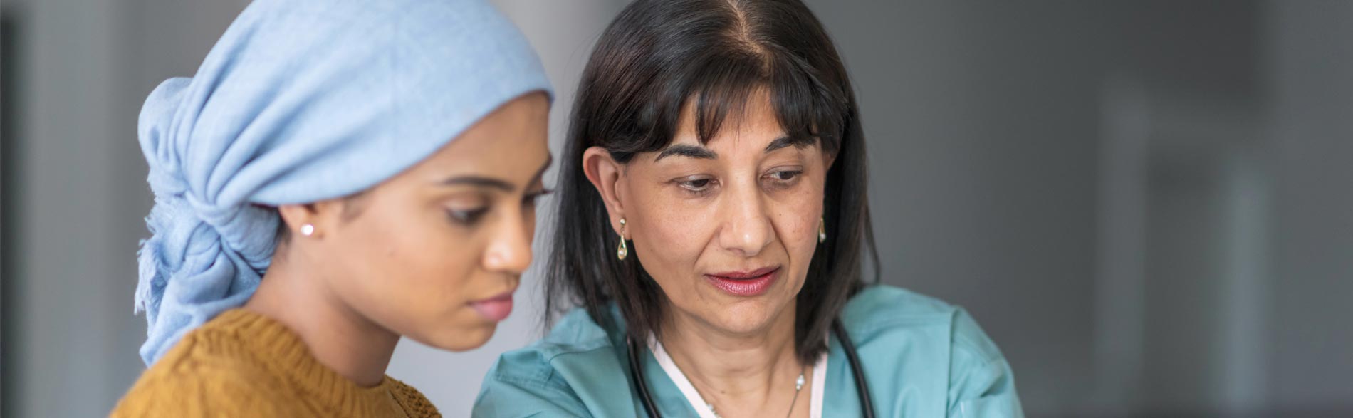 A clinician discusses chronic pain management with a patient in consult