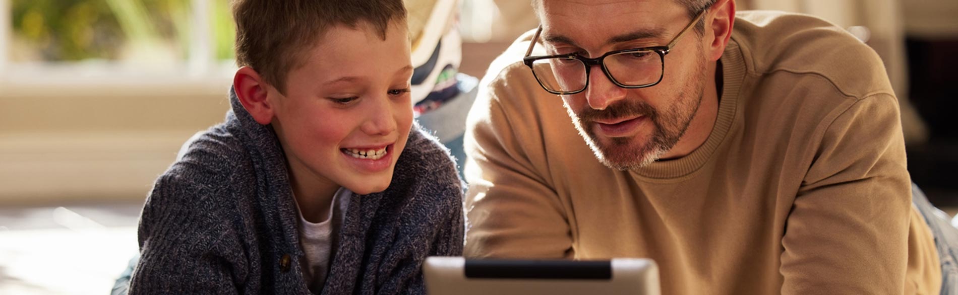 Man looks at some technology with his son to help him with his chronic progressive condition