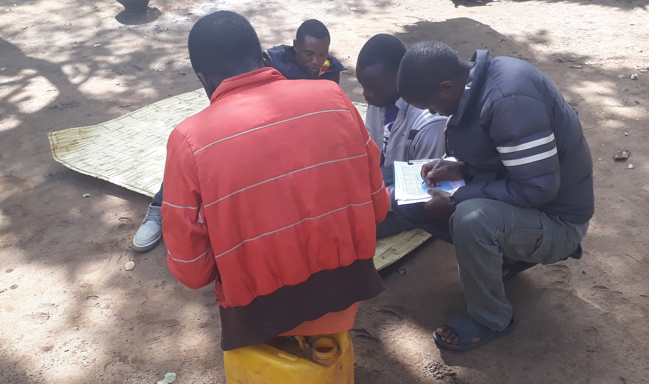 Project team sits outside around hand-written documents