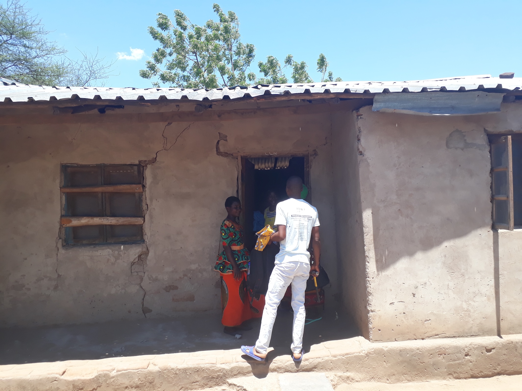 Project team member at a front door talking with local healthcare workers