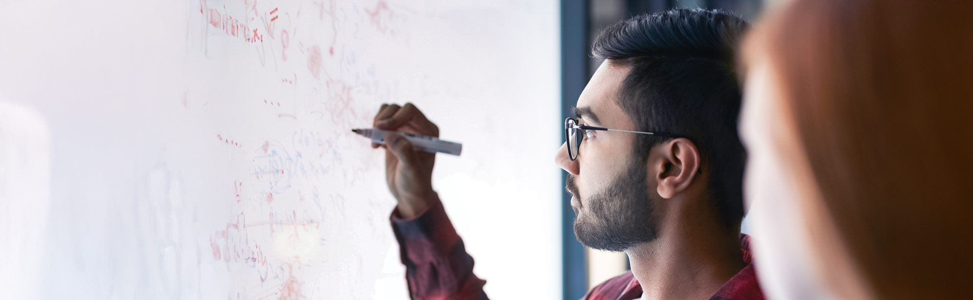 PhD supervisor using a whiteboard to explain something to a student