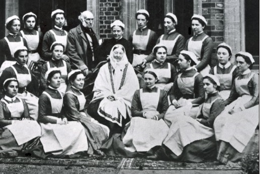 Florence Nightingale at the Nightingale Training School for Nurses, surrounded by nursing staff in a group photo. 