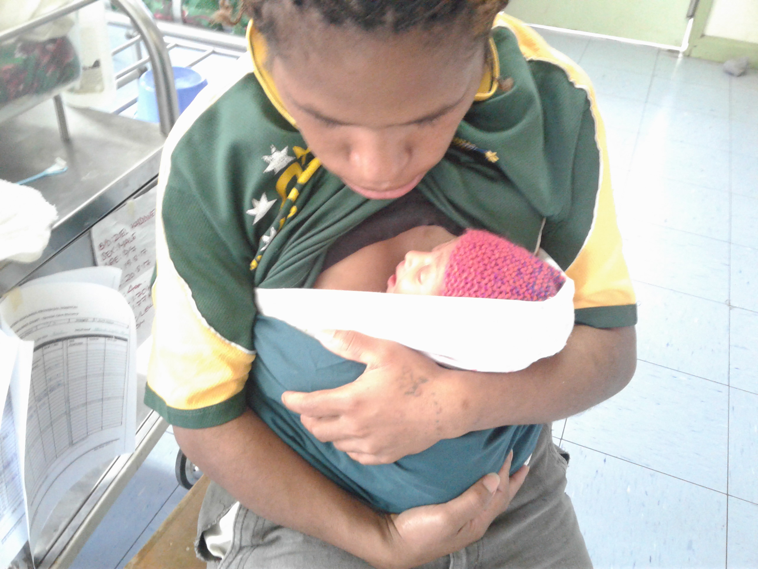 A young boy holding a small baby