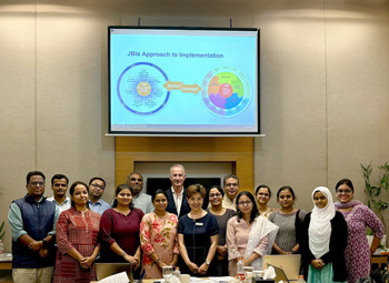 Group photo of 15 Australia Awards Fellows in the classroom with jBI training facilitators in Kolkata, India