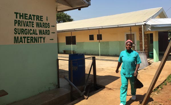 Obstetric clinician walks between hospital buildings