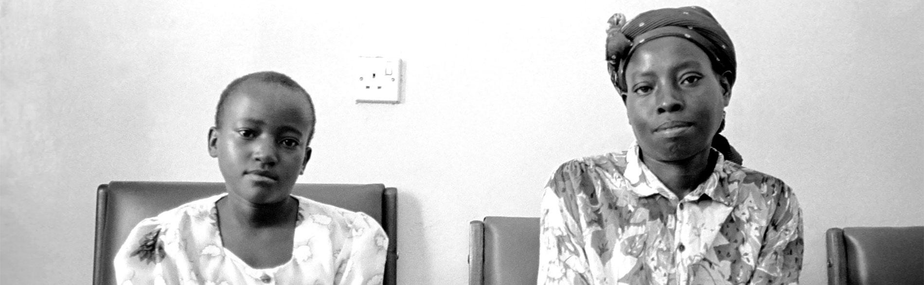 Woman and daughter seated on chairs in waiting room