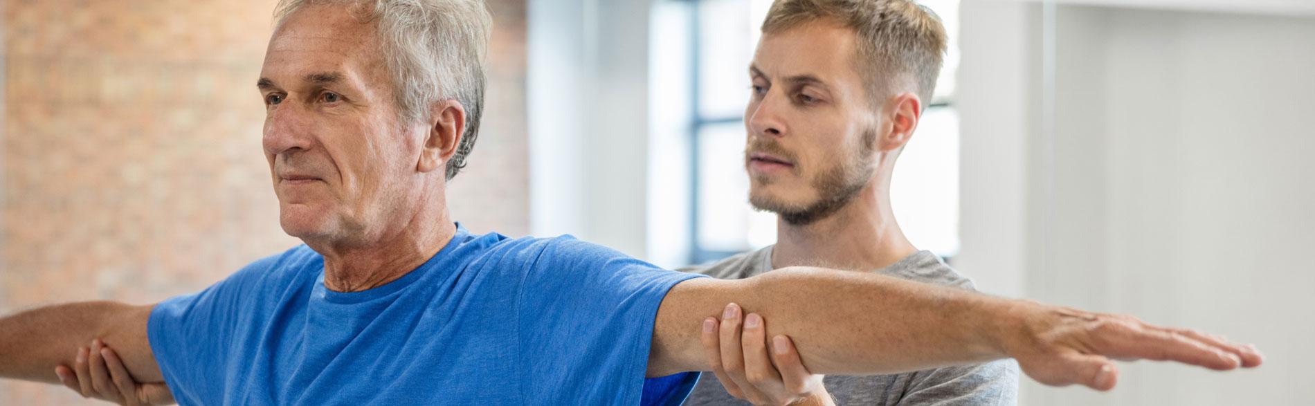 Younger man checks range of motion of older man